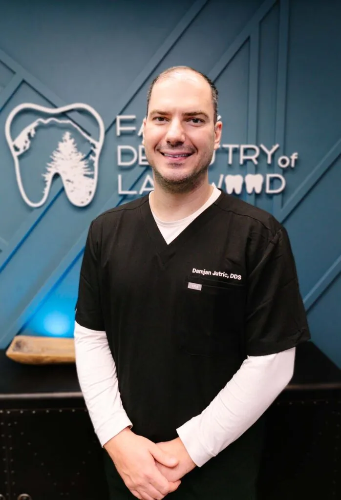 Dr. Damjan Jutric stands in front of the Family Dentistry of Lakewood sign